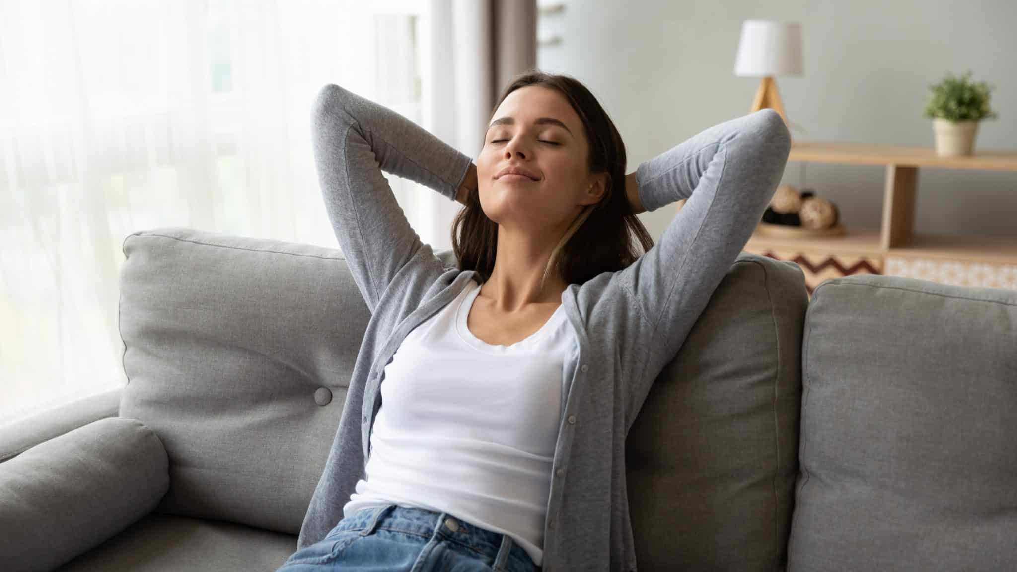 A woman kicks back and relaxes, enjoying the wonderful home air quality created by her whole-home humidifier.