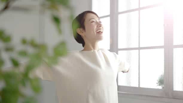 Colorado woman stretching and enjoying her indoor air quality more thanks to having a better HVAC air filtration system.